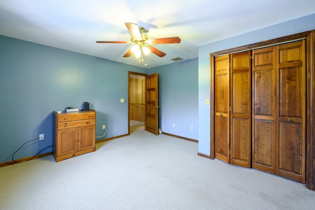 carpeted bedroom featuring ceiling fan and a closet