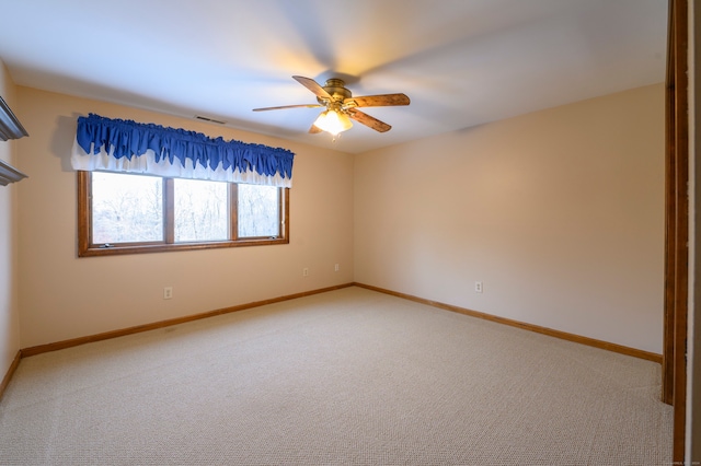 carpeted spare room featuring ceiling fan