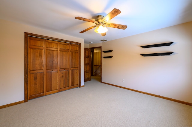 unfurnished bedroom with ceiling fan, light colored carpet, and a closet