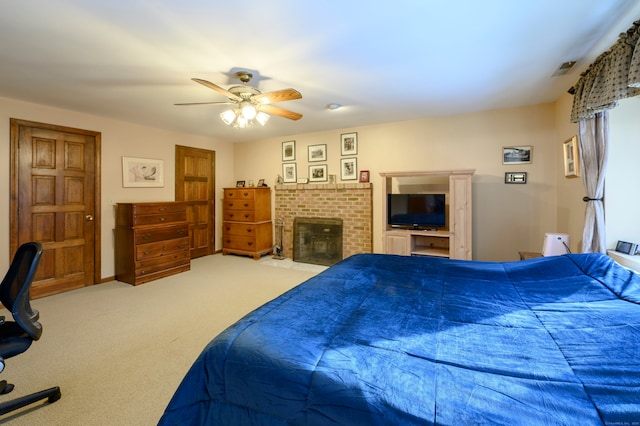 carpeted bedroom with ceiling fan and a fireplace