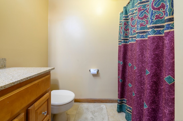 bathroom featuring tile patterned flooring, vanity, and toilet