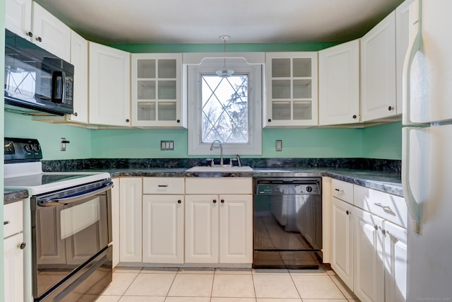 kitchen with sink, black appliances, light tile patterned floors, pendant lighting, and white cabinets