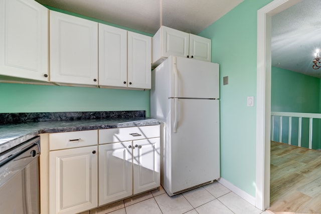 kitchen with white cabinetry, white fridge, stainless steel dishwasher, and a textured ceiling