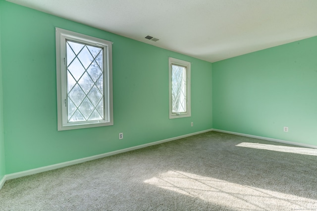 carpeted empty room featuring a healthy amount of sunlight