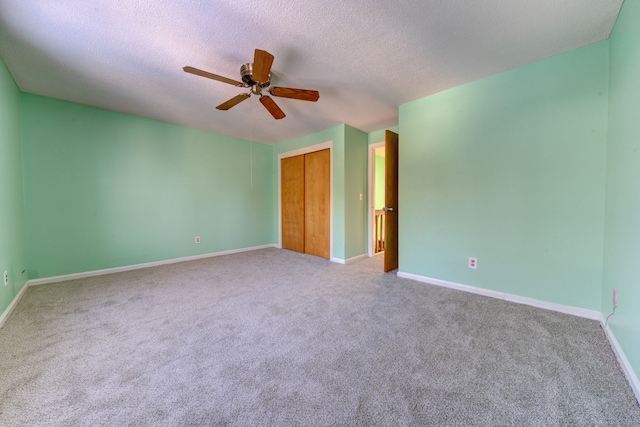 carpeted empty room with ceiling fan and a textured ceiling