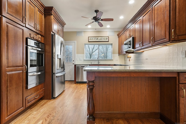 kitchen featuring crown molding, ceiling fan, decorative backsplash, appliances with stainless steel finishes, and light hardwood / wood-style floors