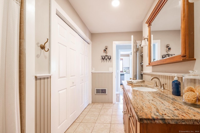 bathroom featuring vanity, visible vents, tile patterned flooring, and wainscoting