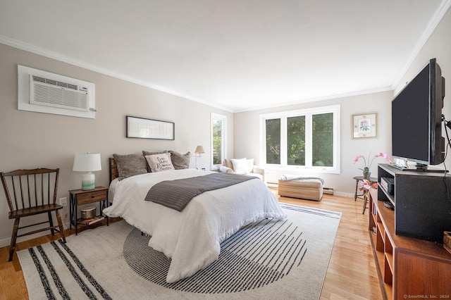 bedroom featuring crown molding, a wall unit AC, light wood-style floors, and baseboards