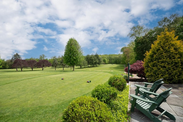 view of home's community featuring a yard and view of golf course