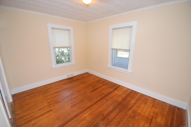 spare room with hardwood / wood-style flooring, plenty of natural light, and ornamental molding