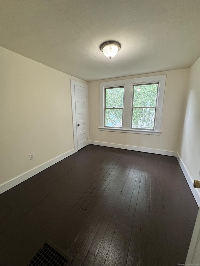 spare room with dark hardwood / wood-style flooring