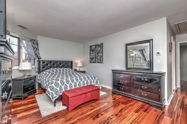 bedroom featuring dark hardwood / wood-style floors and a textured ceiling