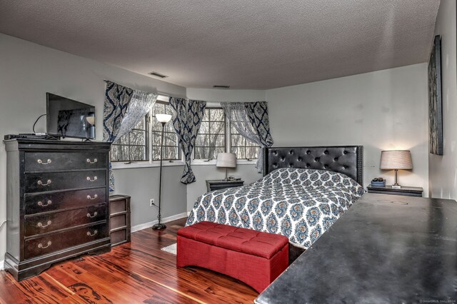 bedroom featuring hardwood / wood-style floors and a textured ceiling