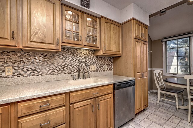 kitchen with backsplash, sink, and stainless steel dishwasher