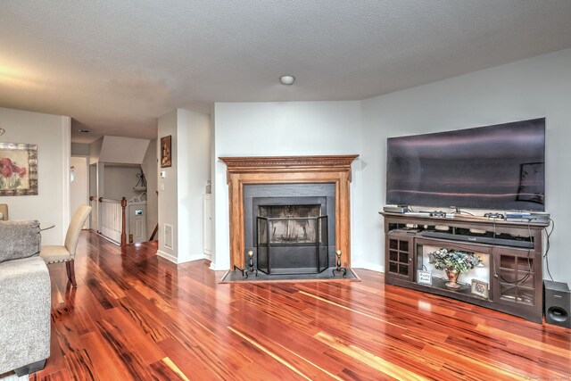 unfurnished living room featuring wood-type flooring and a textured ceiling