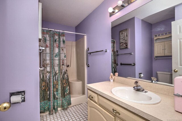 bathroom with a shower with curtain, tile patterned floors, a textured ceiling, toilet, and vanity