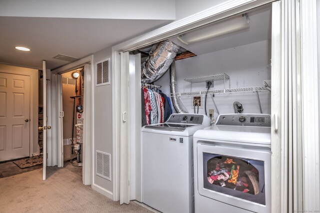 washroom with washing machine and clothes dryer and light colored carpet