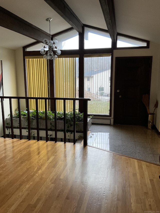 entrance foyer with lofted ceiling with beams, hardwood / wood-style floors, and a chandelier