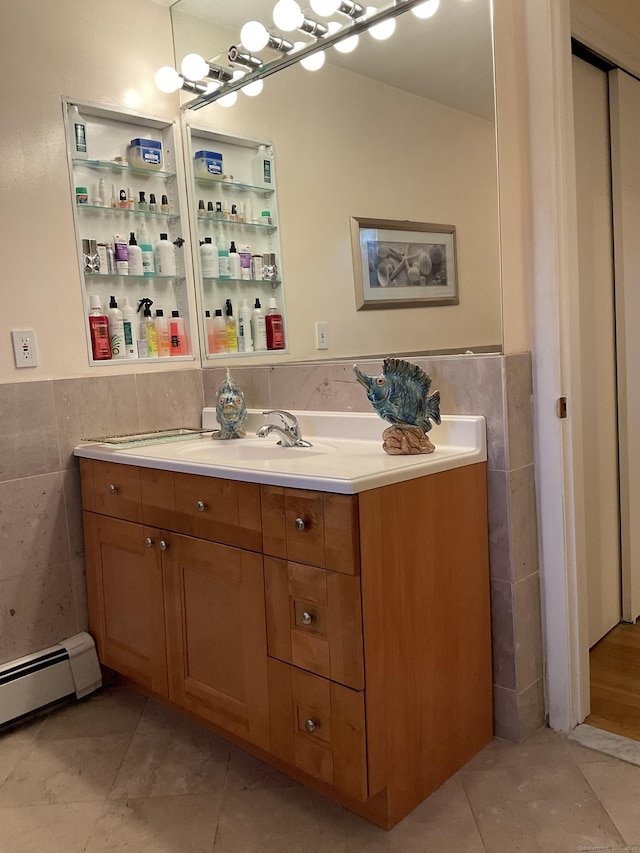 bathroom with vanity, tile patterned floors, tile walls, and a baseboard heating unit