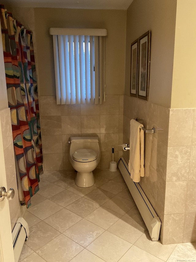 bathroom with tile patterned flooring, a baseboard radiator, and tile walls