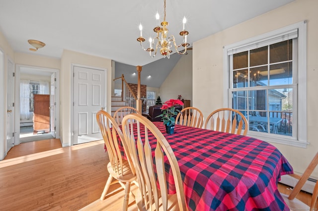 dining space with a notable chandelier, lofted ceiling, baseboard heating, and light hardwood / wood-style flooring