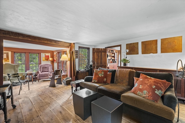 living room featuring beam ceiling and light wood-type flooring