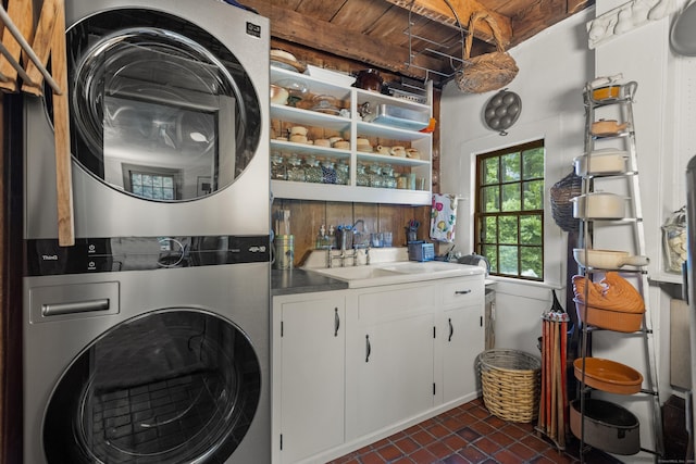 washroom with cabinets, stacked washing maching and dryer, sink, and wood ceiling