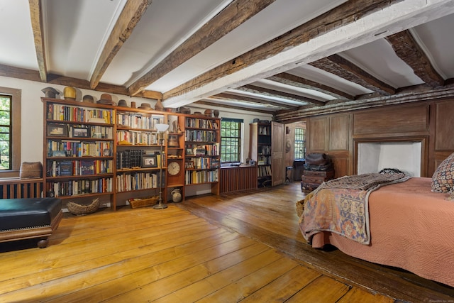 bedroom with beam ceiling and hardwood / wood-style flooring