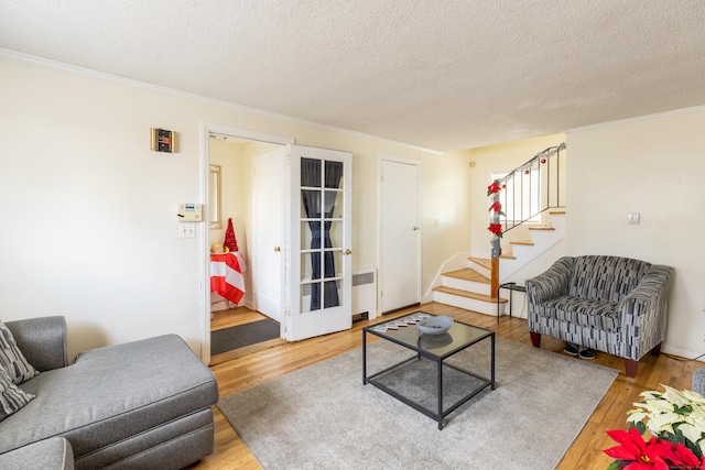 living room featuring radiator heating unit, a textured ceiling, and hardwood / wood-style floors