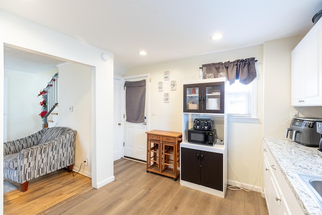 kitchen featuring white cabinetry, light hardwood / wood-style flooring, and sink