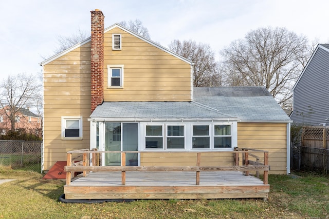 back of house with a sunroom, a deck, and a yard