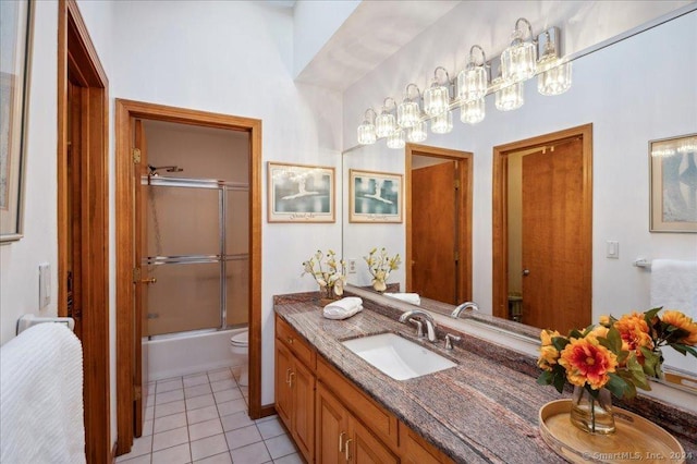 bathroom with tile patterned floors, shower / bath combination with glass door, and vanity