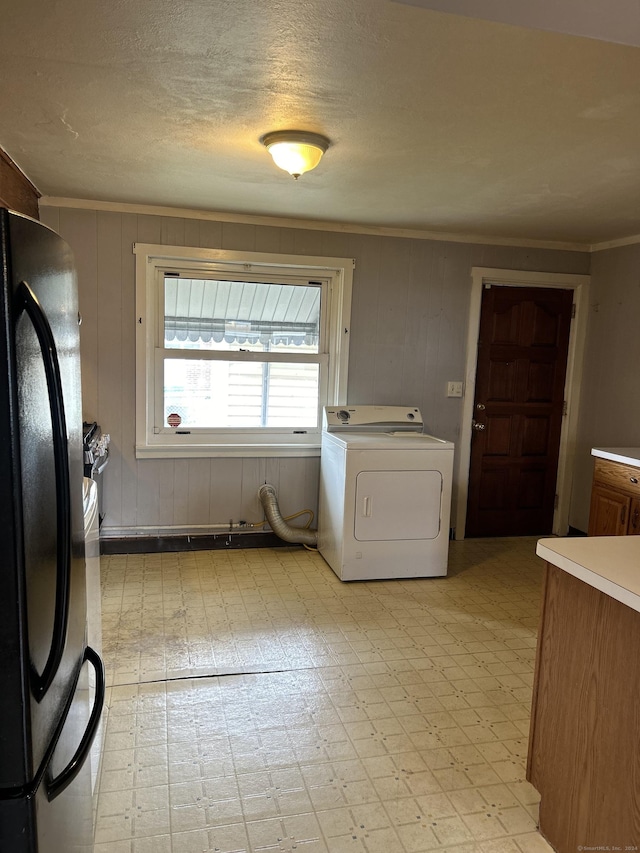 laundry area featuring washer / clothes dryer, wood walls, and crown molding