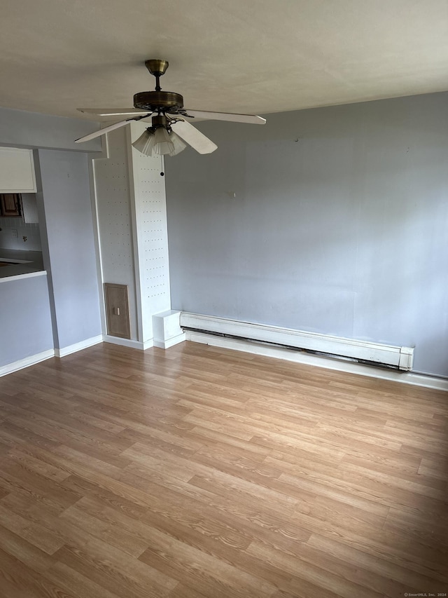 spare room featuring ceiling fan, light hardwood / wood-style floors, and a baseboard heating unit