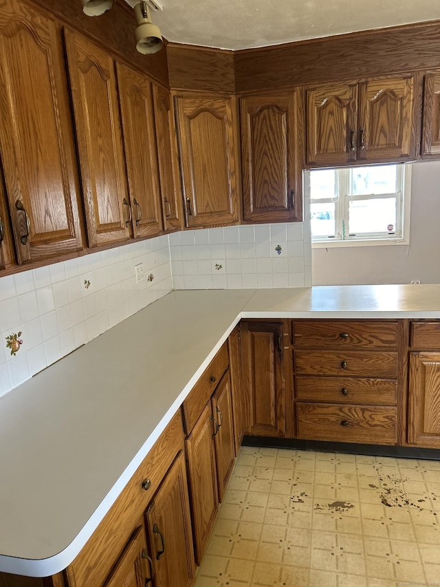 519BDLG-53 Success Ave Unit 519, Bridgeport, CT 06610 - kitchen featuring light flooring, brown cabinetry, decorative backsplash, and light countertops
