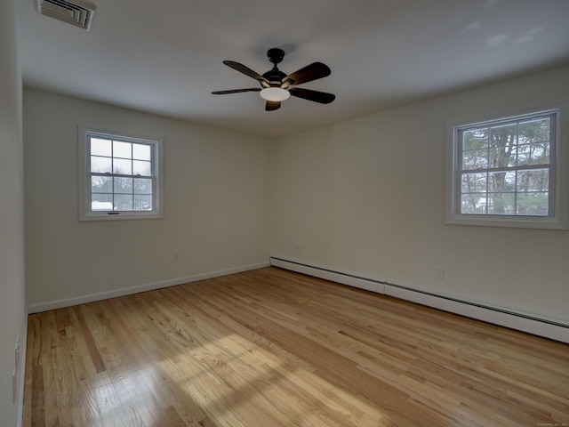 spare room with a baseboard radiator, ceiling fan, and light hardwood / wood-style floors