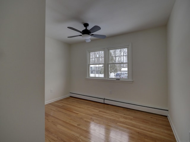 empty room with ceiling fan, light wood-type flooring, and baseboard heating