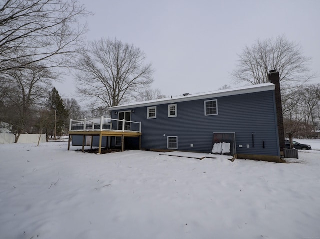 snow covered house featuring a wooden deck