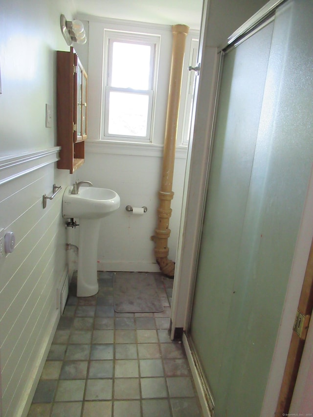 bathroom featuring tile patterned flooring, a shower with door, and sink