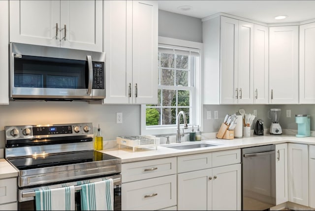 kitchen featuring white cabinets, sink, and appliances with stainless steel finishes