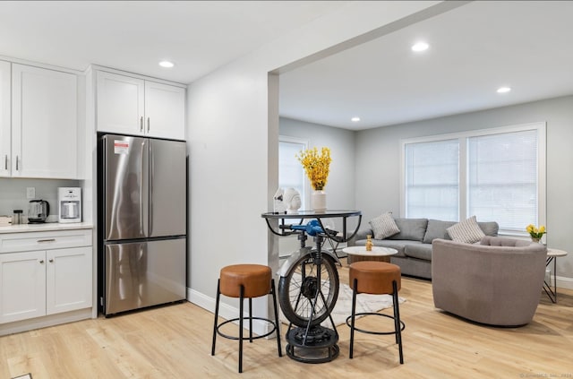 kitchen featuring white cabinets, stainless steel fridge, and light wood-type flooring