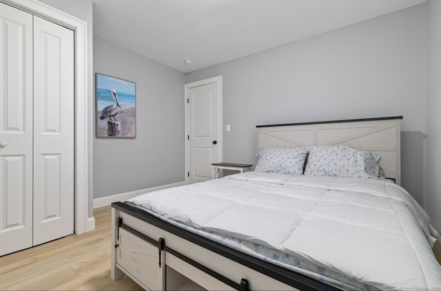 bedroom with light hardwood / wood-style flooring and a closet