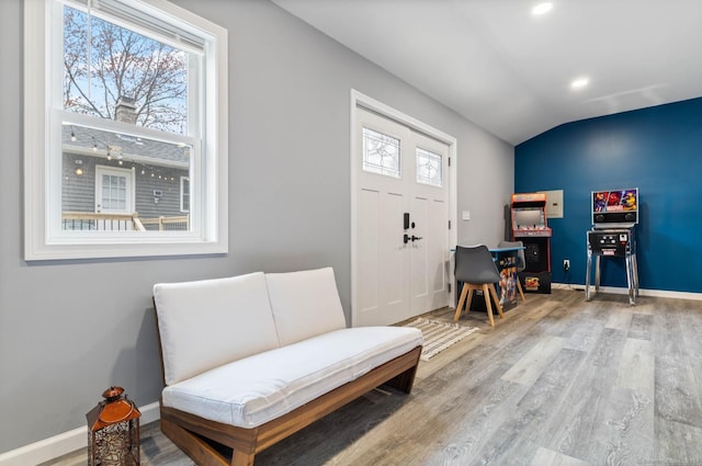 living area featuring hardwood / wood-style floors, vaulted ceiling, and a healthy amount of sunlight