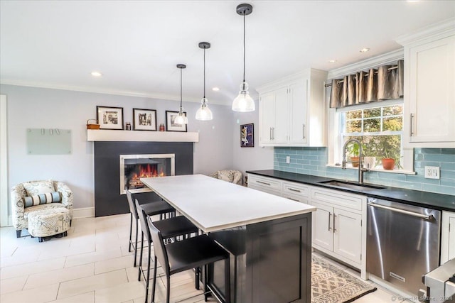 kitchen with dishwasher, sink, a kitchen island, a breakfast bar, and white cabinets