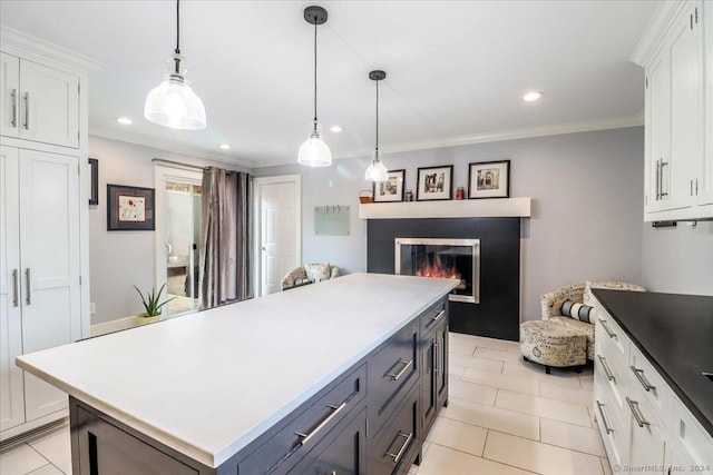 kitchen with decorative light fixtures, white cabinetry, and crown molding