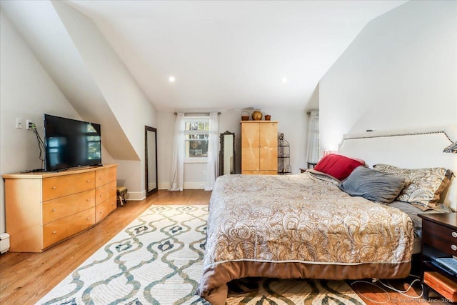 bedroom with light hardwood / wood-style flooring and lofted ceiling