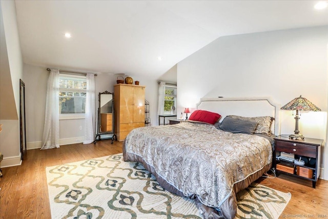 bedroom featuring lofted ceiling and light hardwood / wood-style flooring