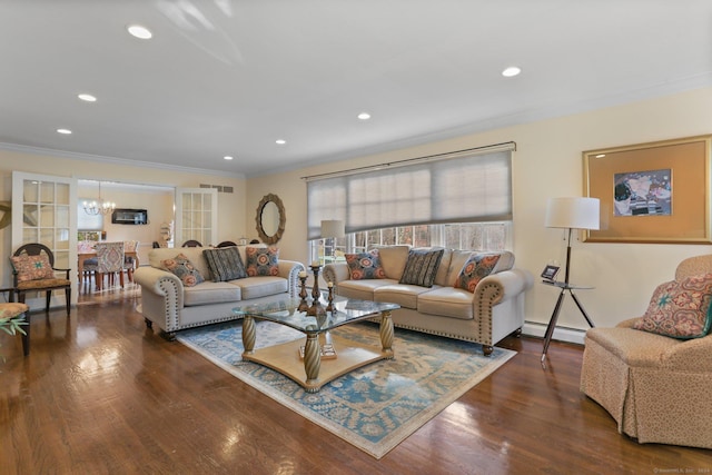 living room with a notable chandelier, crown molding, dark hardwood / wood-style flooring, and baseboard heating