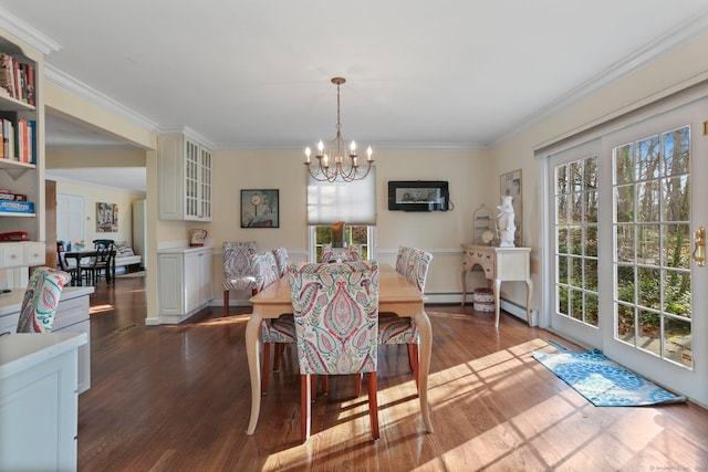 dining area featuring hardwood / wood-style floors, crown molding, and an inviting chandelier