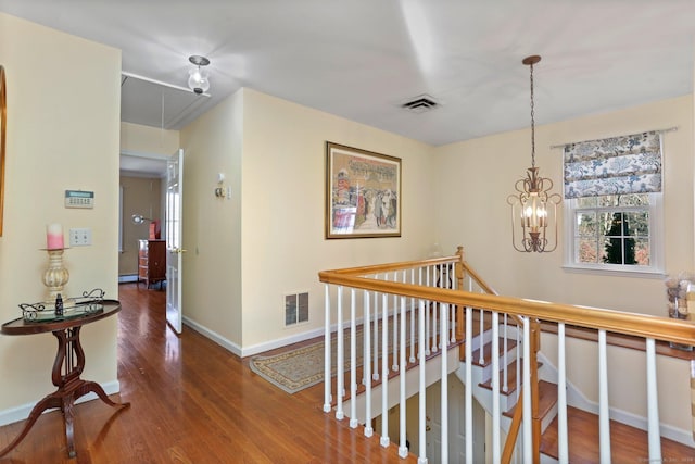 corridor featuring a notable chandelier and dark hardwood / wood-style flooring